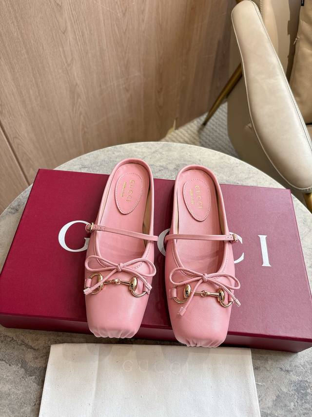 9099-1C 粉￥ 35-42 2025秋冬系列, 这款马衔扣平底芭蕾穆勒鞋选用方形收口鞋头设计，搭配雅致的蝴蝶结细节，致敬传统芭蕾舞鞋款型。这款单品以皮革匠