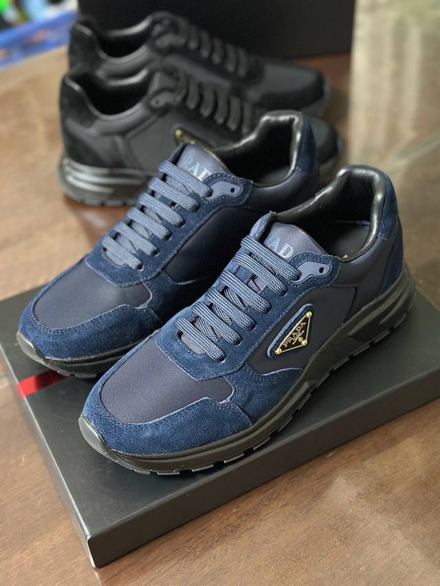 2Ee436 这款运动鞋以Re-Nylon与绒面牛皮革鞋面呈现混搭风动感廓形，搭配舒适的鞋底。重新诠释经典款型prax，饰以pra＊＊徽标。 带徽标鞋带 鞋面饰