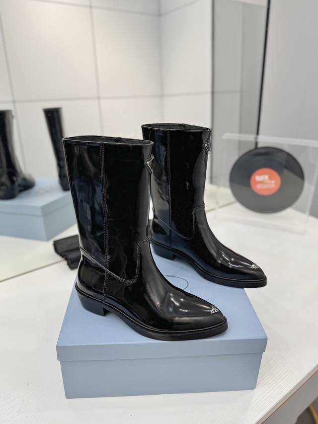 工厂p价 秋冬新款prada普拉达尖头三角标直筒骑士靴马丁靴 这款皮革靴撷取简约美学风格，诠释当代设计精髓，塑就丰盈立体的廓形。流畅构型与金属刻字徽标彰显鲜明个