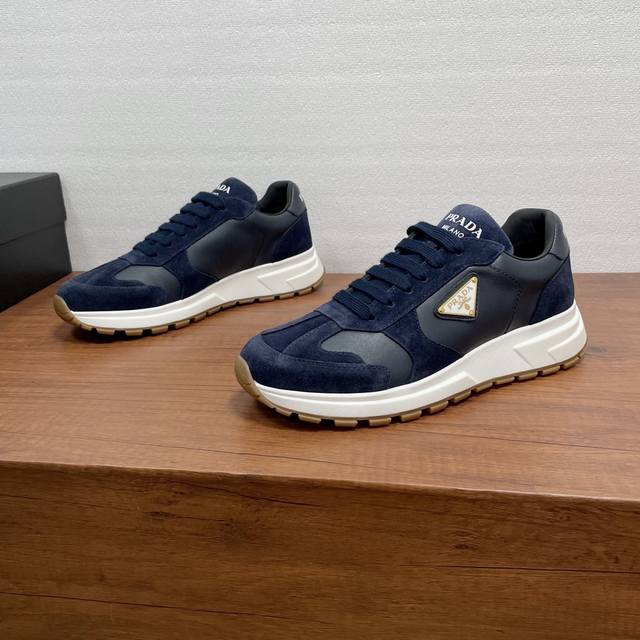 prada prax系列男士休闲运动鞋 这款prax运动鞋将风格与舒适融为一体，独特的运动设计由精致的材质和细节定义。采用绒面牛皮革和光滑小牛皮拼接鞋面打造，时