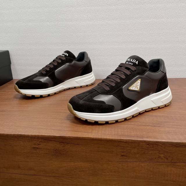 prada prax系列男士休闲运动鞋 这款prax运动鞋将风格与舒适融为一体，独特的运动设计由精致的材质和细节定义。采用绒面牛皮革和光滑小牛皮拼接鞋面打造，时