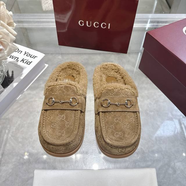 秋冬新款反绒牛皮马衔扣女士羊毛拖鞋 Gg在 冬季系列中继续使用档案符号。Horsebit 硬件让人想起品牌的马术传统，出现在这双 Camel 和牛皮高周波压 G