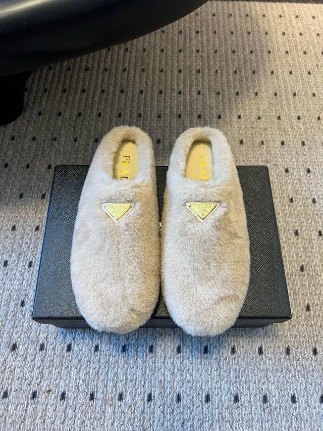 prad* 25Ss 三角标毛绒穆勒鞋 采用毛绒材质，触感柔软舒适，能为脚部提供温暖的穿着体验，适合秋冬季节。有米色、白色、黑色、深紫色、棕色等多种颜色可选，满