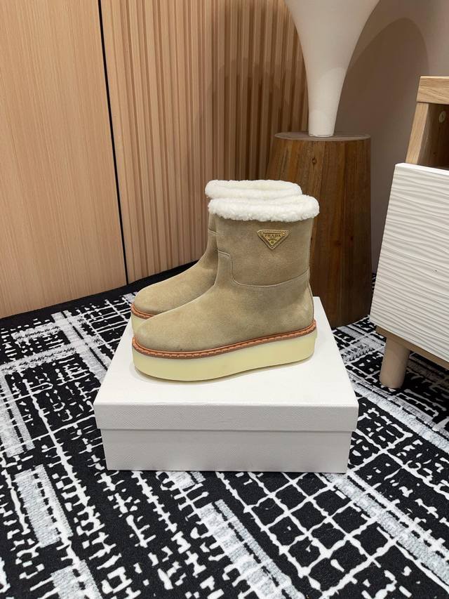 25Ss秋冬新款prada三角标厚底羊毛里短靴雪地靴 这款简约厚底毛里雪地靴取材羊羔毛打造。新意迭出的三角形徽标重释为经典元素！ 鞋面：双色擦色牛绒 内里：真羊