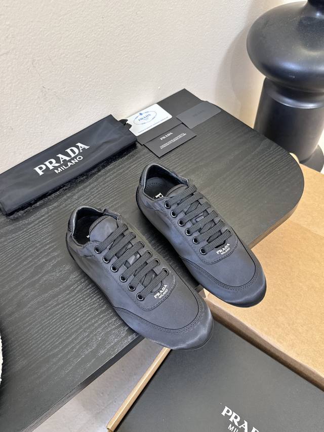prad**经典款运动鞋复古德训鞋休闲鞋 采用复古德训鞋的低帮流线型廓形，鞋头为尖圆头设计，整体线条利落简约；鞋舌处印有prada经典Logo，鞋带与鞋身同色呼