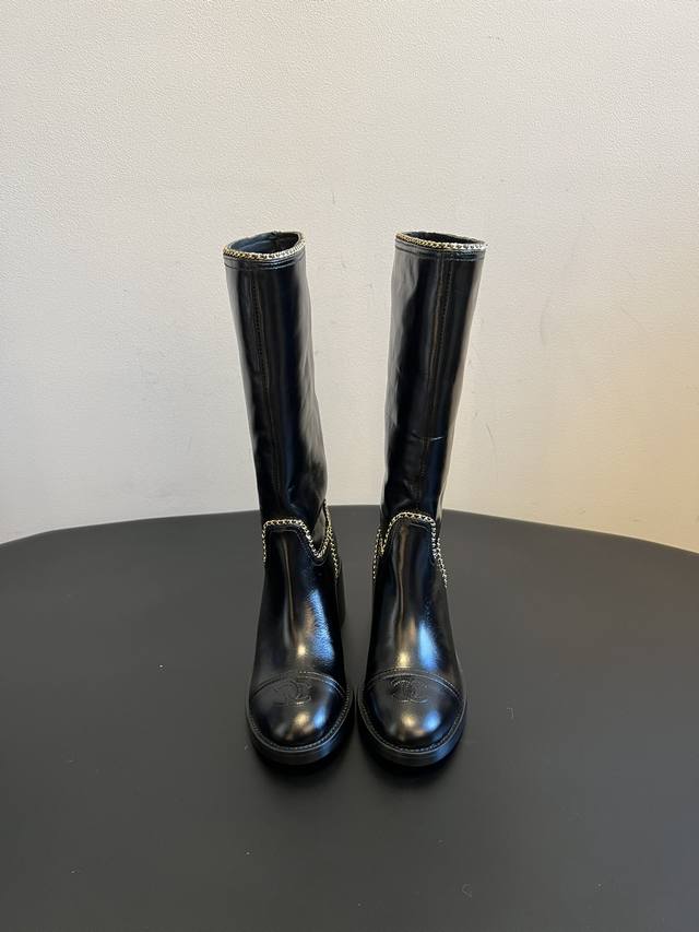 Chane* 25Ss秋冬新款链条中筒靴 采用弹性小羊皮+小牛漆皮的组合，既有羊皮的柔软贴合，又有漆皮的挺括光泽。鞋身缝线处嵌入了品牌经典的金属链条装饰，鞋头带