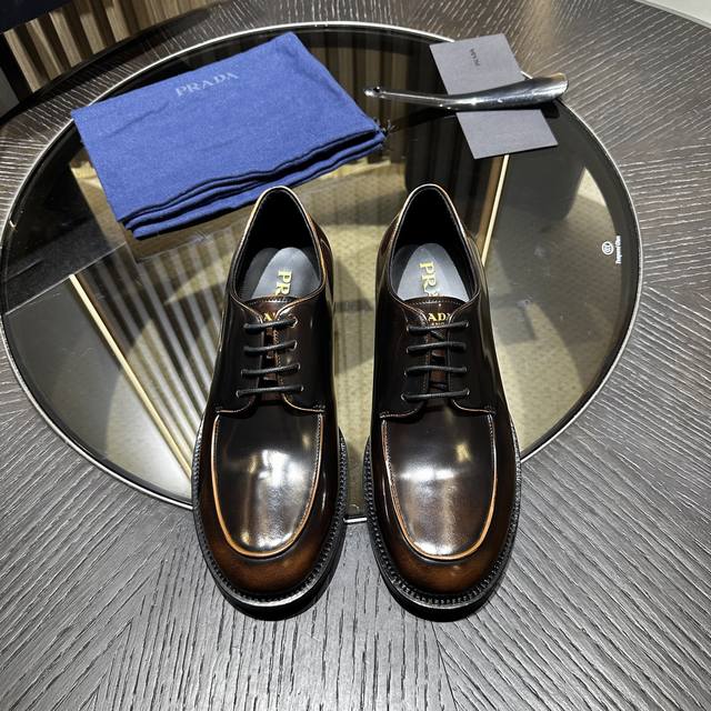 Prad* 普拉达男士商务皮鞋 DDD 这款哑色小牛皮乐福鞋饰以涂珐琅金属刻字徽标，鞋面富有光泽，设计感十足。真皮大底。 DDD Size：39-44 38.4