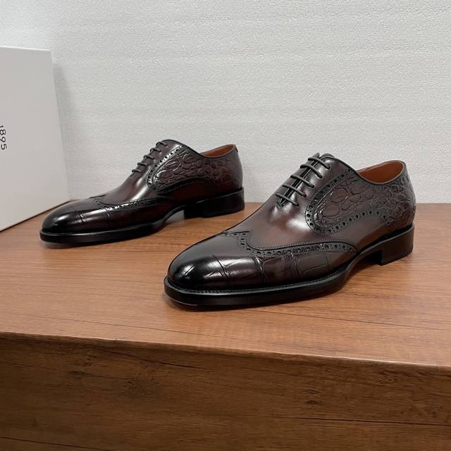 Berluti 男士新款商务正装牛津鞋 DDD 这款牛津鞋采用进口小牛皮胚面，巧妙融合鳄鱼背纹和肚皮压纹及光滑牛皮革效果鞋面，经典布洛克雕花点缀，纯手工擦色工艺