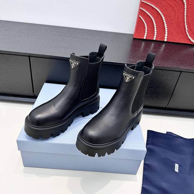 代购版 DDD Prada普拉达2025秋冬新款 P家切尔西厚底短靴，以开边珠牛皮塑造酷感轮廓，三角徽标彰显品牌辨识度，厚底设计迸发潮酷张力。无论是搭配裙装打造