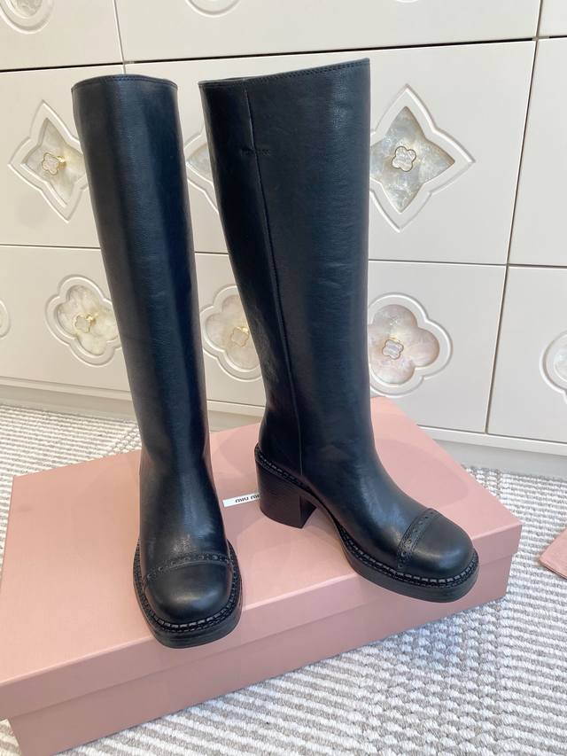 Miu Mi*甜酷风黑色粗跟高筒靴 长靴 DDD 经典高筒靴型，搭配圆头+粗跟厚底，鞋头有布洛克雕花细节，靴筒边缘的银色缝线装饰是亮点，既简约又有辨识度，甜酷风