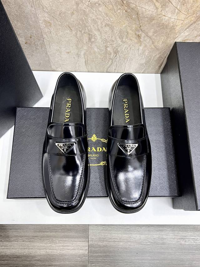 Prad* 普拉达男士商务皮鞋 DDD 这款哑色小牛皮乐福鞋饰以涂珐琅金属刻字徽标，鞋面富有光泽，设计感十足。真皮大底。 DDD Size：38-44 45.4