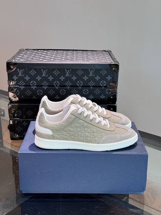 D～R 新款 B01 运动鞋是d家经典单品，鞋面采用原版牛皮绒面革以及由 Daniel Arsham 重新诠释的“Di*R”徽标装饰。鞋面顶部采用白色系带，与富