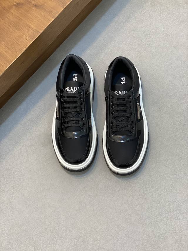 Prad* 普拉达 24春夏新品男士高端运动鞋，这款运动鞋时尚百搭，简洁现代，融合运动风格和精致细节。选用皮革材质打造，搭配橡胶鞋底，鞋舌压印字母徽标，简约时尚
